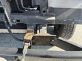 Close-up view of the rear hitch and frame of a 2012 Ford Econoline showing rust and wear on the metal components