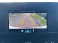 A rearview camera display showing a clear view of a road with double yellow lines and guidelines for parking assistance in a 2024 Mercedes-Benz Sprinter 2500
