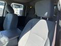 Interior of a 2015 RAM 1500 showing front seats with cloth upholstery and a center console