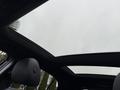 A panoramic sunroof of a 2016 Mercedes-Benz GLA-250 displaying a cloudy sky with raindrops on the glass