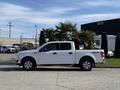A 2018 Ford F-150 in white with four doors and a prominent 4x4 emblem on the side