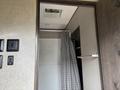 Interior view of a 2021 Jayco Jay Flight showing a shower area with a patterned curtain and cabinetry beside it