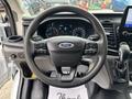 Steering wheel of a 2020 Ford Transit 250 featuring controls for audio and cruise settings with a Ford logo in the center