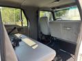 Interior of a 2006 Sterling Acterra truck featuring a driver's seat a passenger seat and a gray bench seat with a steering wheel and dashboard visible