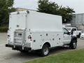 A 2008 Ford F-450 SD in white with a boxy service body and various storage compartments on the sides
