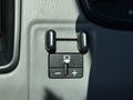 Close-up of a control panel in a 2018 GMC Canyon featuring two knobs and a button with a light symbol indicating a feature adjustment