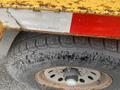 Close-up of a tire and wheel from a 2010 Vermeer Corporation BC1000XL with visible tread patterns and a portion of the vehicle's side showing rust and reflective markings