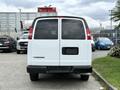 A 2021 Chevrolet Express van viewed from the rear with a white exterior and rear doors closed