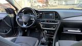 Interior view of a 2018 Hyundai Sonata showing the steering wheel dashboard and gear shift with controls and screen visible