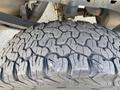Close-up of a worn tire with deep tread patterns mounted on a 2018 Ford F-150 showcasing substantial wear and rugged design for off-road capability