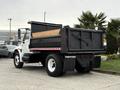 A white 2006 International 4200 dump truck with a black dump bed and red and white reflective striping on the rear