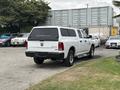 A white 2013 RAM 1500 parked with a camper shell and 4x4 badge visible on the rear