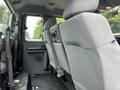 The interior of a 2013 Ford F-250 SD showing the backseat area with gray upholstery and storage compartments