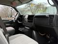 Interior view of a 2008 Chevrolet Express featuring a driver's seat passenger seat and dashboard with a mounted display and various controls