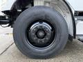 Close-up of a black wheel rim with ten bolt holes mounted on a large tire of a 2015 Freightliner M2 truck
