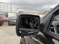 A side mirror of a black 2018 RAM 1500 showing the reflection of an empty interior and a glimpse of vehicles behind it