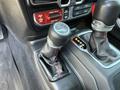 Close-up of the gear shift and transfer case selector in a 2021 Jeep Wrangler showing the leather boot and buttons for four-wheel drive mode