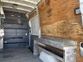 Interior of a 2010 Mercedes-Benz Sprinter van with wooden paneling and metal seating area along the side