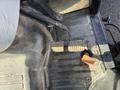 Close-up of the foot pedals in a 2010 New Holland T4050 tractor showing the brake and clutch pedals with textured surfaces
