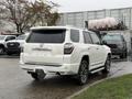 A white 2018 Toyota 4Runner with a sporty design and tinted windows is parked with its back facing the viewer
