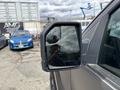 A 2019 Ford F-150 side mirror reflecting a cloudy sky and a faint image of a person