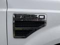 A close-up of a chrome badge reading F-250 SUPER DUTY on the side of a white 2008 Ford F-250 SD with water droplets on the surface