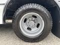 A close-up view of a 2020 Chevrolet Express wheel featuring a silver rim and rugged tread tire mounted on a black background