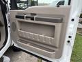 A beige door panel of a 2008 Ford F-450 SD featuring a handle and storage compartments