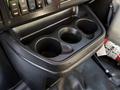 A black cup holder with three compartments in the front console of a 2019 Chevrolet Express