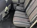 The interior of a 2018 Ford F-150 featuring a rear bench seat with patterned upholstery and a rubber floor mat