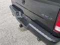 A black 2018 RAM 1500 truck's rear bumper showing a step area and hitch receiver with visible bolt holes