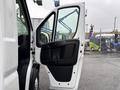 A white 2023 RAM Promaster 3500 van with the driver's side door open displaying a black interior panel and handle