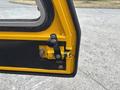 Close-up of a yellow and black door latch mechanism from a 2004 Bombardier SW48 showcasing the locking mechanism and handle
