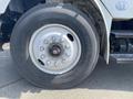 Close-up of a Bridgestone tire mounted on a white wheel of a 2017 Freightliner M2 106 truck showing the wheel's lug nut arrangement