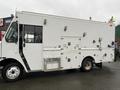 A 2012 Workhorse W62 delivery truck with a white exterior featuring multiple side compartments and a rear door for cargo access
