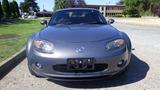 A gray 2007 Mazda Miata with a sleek design and prominent front grille is parked facing the camera