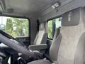 Interior view of a 2013 Kenworth T370 featuring two cloth seats with armrests and a dashboard with driving controls