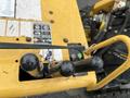 A close-up view of the control levers on a 2014 Vermeer Corporation Sweep Stump Cutter showing two black levers and a green button