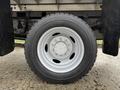 A close-up view of the white wheel rim and black tire of a 2012 Ford F-550 showing the tread pattern and bolt design
