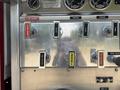 A metallic control panel featuring various switches and gauges labeled for fire and water pump operations on a 1999 Freightliner FL80