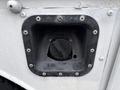 Fuel filler opening of a 2000 Ford F-450 with a circular cap and a textured black surround