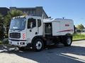A white 2012 Autocar XPERT street sweeper with a side-mounted broom and logo on the body, designed for cleaning roads and public spaces