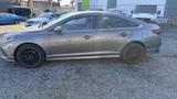 A gray 2018 Hyundai Sonata with black wheels parked on gravel