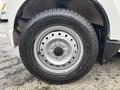A close-up of a silver wheel and tire from a 2008 Suzuki Carry showing five lug nuts and treads on the tire