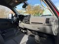 Interior view of a 2013 Chevrolet Silverado 3500HD featuring gray fabric seats a steering wheel and dashboard with controls and instruments