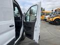 A 2023 Ford Transit van with an open sliding door revealing the interior space and driver's seat