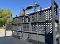 A 2020 Peterbilt 330 truck with a flatbed and black metal lattice design on the rear side