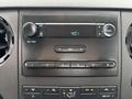 A car dashboard featuring a radio display with buttons for audio control and climate settings in a 2013 Ford F-250 SD