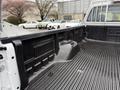 A 2008 Ford F-250 SD truck bed with a textured black liner and a smooth section for storage near the cab