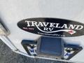 A close-up of a Traveland RV sticker on a recreational vehicle with the establishment year 1977 and the website TravelandRV.ca